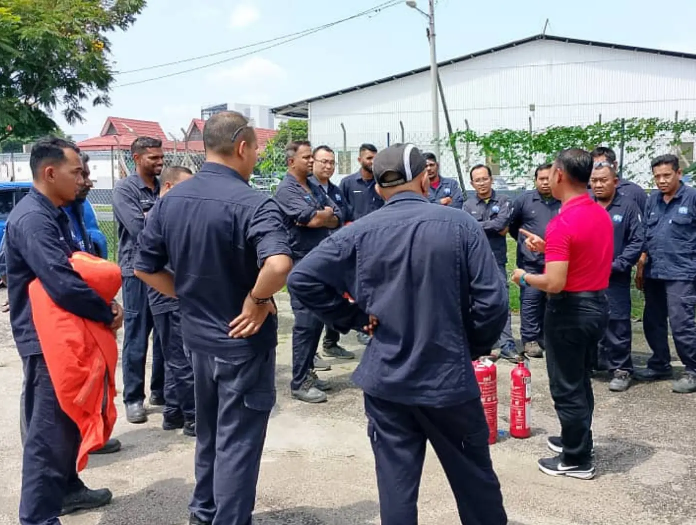 Trainer conducting practical fire drill training with participants