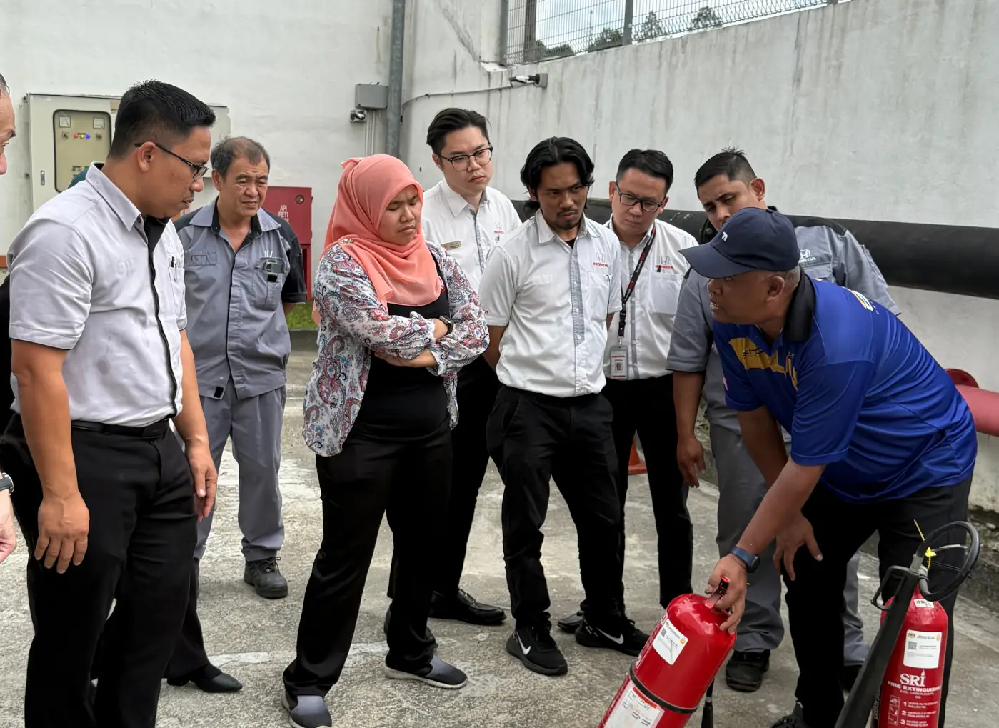 Workplace participants learning fire extinguisher use during practical fire safety training